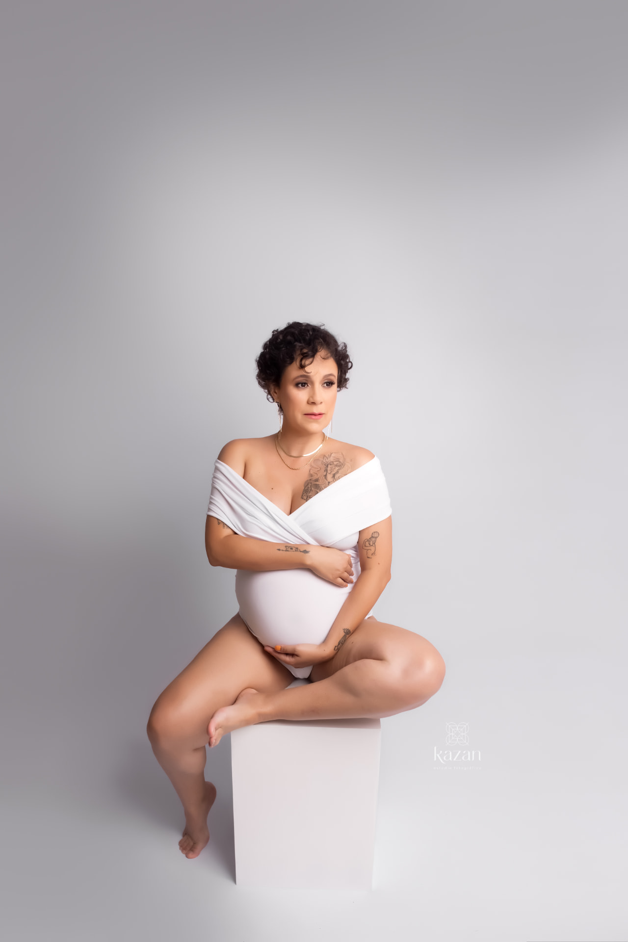 Karen em ensaio fotográfico, vestida de branco sobre fundo neutro
